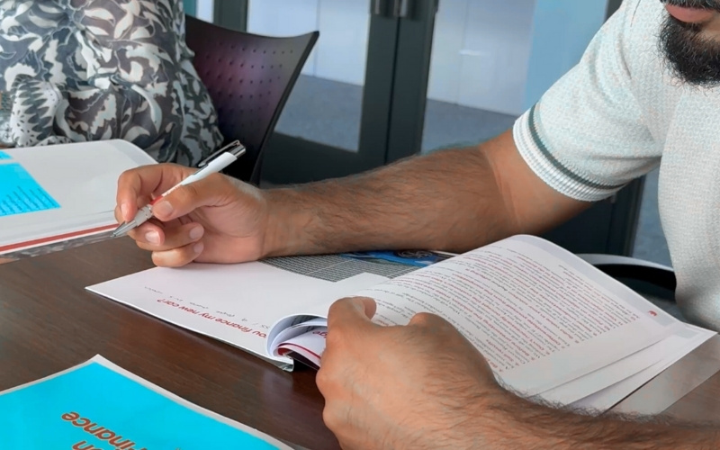 learner at FEC makes notes in notebook on desk
